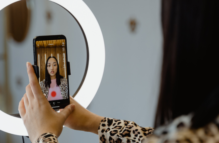 Photo d'une femme en live sur les réseaux sociaux sur son téléphone